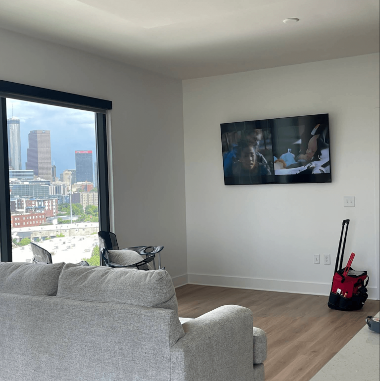 TV wall mounted in high-rise apartment with downtown Atlanta view